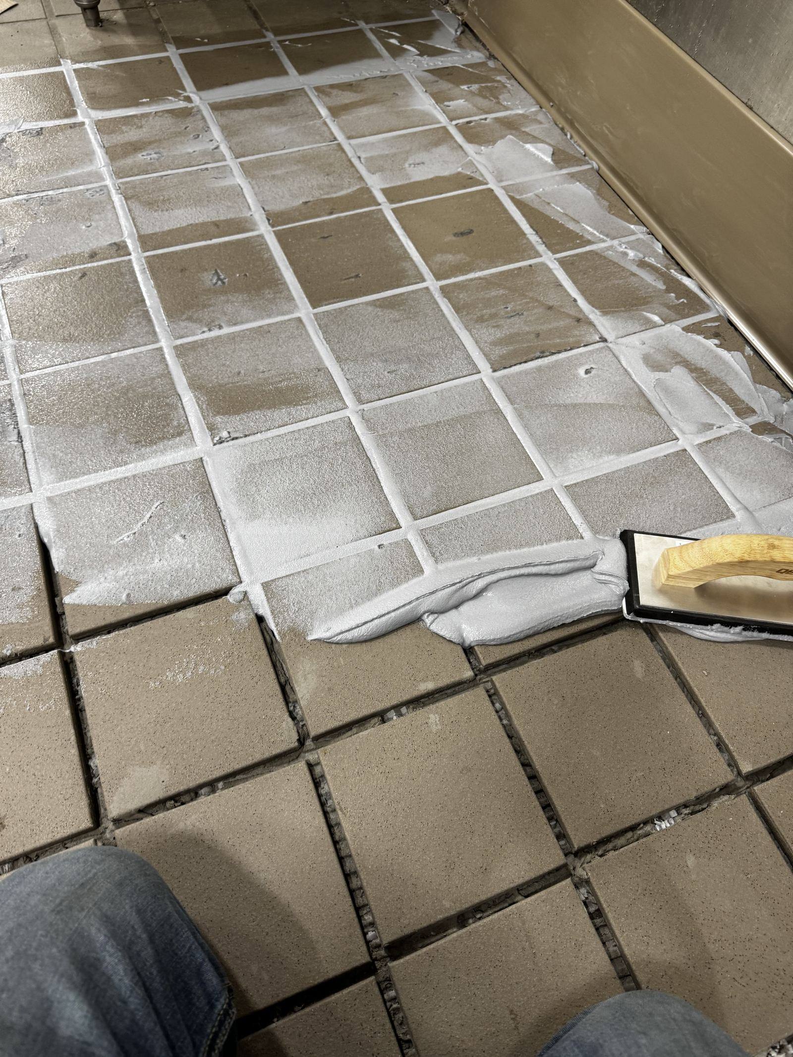 Fresh grout being floated into commercial kitchen tile